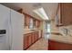 Kitchen with wood cabinetry, neutral countertops, updated appliances, and tile flooring at 14047 Briardale Ln, Tampa, FL 33618