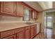 Galley style kitchen features tile flooring, ample counter space, wood cabinetry, stainless steel sink and bright natural light at 14047 Briardale Ln, Tampa, FL 33618