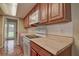 Galley style kitchen with wood cabinetry, tile flooring, and modern appliances at 14047 Briardale Ln, Tampa, FL 33618