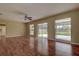 Large living room with wood-look floors, ceiling fan, and sliding doors to the patio at 14047 Briardale Ln, Tampa, FL 33618