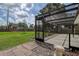 View of the screened patio with brick pavers, concrete floors, and a spacious grassy yard, creating an ideal outdoor space at 14047 Briardale Ln, Tampa, FL 33618