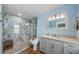 Modern bathroom with glass enclosed shower with stone tiling, granite countertops, and wood-look flooring at 14534 Yacht Club Blvd, Seminole, FL 33776