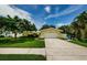 Lovely one-story yellow home featuring a wide driveway, attached garage, and well-maintained landscaping at 14534 Yacht Club Blvd, Seminole, FL 33776