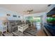 Open living room with hardwood floors, a comfortable gray sofa, and views of the dining area and backyard at 14534 Yacht Club Blvd, Seminole, FL 33776
