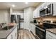 Modern kitchen features white cabinets, stainless steel appliances, gray counter tops, and plank flooring at 14819 Summer Branch Dr Dr, Lithia, FL 33547