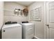 Well-lit laundry room featuring modern washer and dryer, overhead shelving, and decorative wall art at 14819 Summer Branch Dr Dr, Lithia, FL 33547