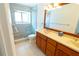 Modern bathroom featuring double sinks, tile floors, and a glass-enclosed shower at 15028 Redcliff Dr, Tampa, FL 33625