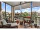 Screened in balcony with seating that offers a view of a lake and the surrounding community at 1536 Ember Ln, Tarpon Springs, FL 34689