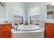 Bathroom featuring a soaking tub, tile floors, and dual vanities at 1536 Ember Ln, Tarpon Springs, FL 34689