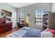 Comfortable bedroom with a desk, TV, and ample natural light from the two windows at 1536 Ember Ln, Tarpon Springs, FL 34689