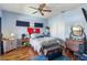 Bedroom with a ceiling fan, wood floors, a red flag, and a vintage dresser at 1536 Ember Ln, Tarpon Springs, FL 34689