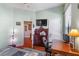 Bedroom with wood floors, a desk, a tv on the wall, and a lighted decorative floor lamp at 1536 Ember Ln, Tarpon Springs, FL 34689