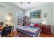 Bedroom featuring wood floors, a desk, a bookshelf, and a large painting on the wall at 1536 Ember Ln, Tarpon Springs, FL 34689