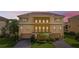 Elegant townhome showcasing beautiful architectural details, three garage doors, and lush landscaping at 1536 Ember Ln, Tarpon Springs, FL 34689
