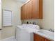 Laundry room with washer, dryer, cabinets, and utility sink at 1536 Ember Ln, Tarpon Springs, FL 34689