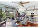 Inviting living room with a ceiling fan, access to a balcony, and an open view of the kitchen and dining area at 1536 Ember Ln, Tarpon Springs, FL 34689