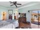 Main bedroom featuring a tray ceiling, a ceiling fan, wood floors, and access to an outdoor balcony at 1536 Ember Ln, Tarpon Springs, FL 34689