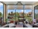 Relaxing screened-in patio with wicker furniture overlooking lush greenery and water views at 1536 Ember Ln, Tarpon Springs, FL 34689