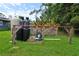 Water filtration system in backyard with lush green grass and mature trees at 1609 Haven Bnd, Tampa, FL 33613
