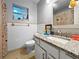 Bathroom features granite countertops, a decorative mirror, and a window for natural light at 1609 Haven Bnd, Tampa, FL 33613