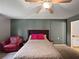 Bedroom features a cozy red chair, decorative accents, and a comfortable bed with pink pillows at 1609 Haven Bnd, Tampa, FL 33613