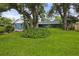 Charming single-story home with a blue facade and lush green lawn and mature shade trees at 1609 Haven Bnd, Tampa, FL 33613