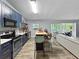 Stylish kitchen with an island and bar seating, seamlessly connected to the living area and sunroom at 1609 Haven Bnd, Tampa, FL 33613