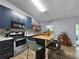 Modern kitchen featuring blue cabinetry, stainless steel appliances, and a center island with seating at 1609 Haven Bnd, Tampa, FL 33613
