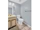 Cozy bathroom with blue walls, tiled floors, toilet and a mirror with a vanity at 1715 Larabie Ct, Brandon, FL 33511
