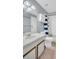 Well-lit bathroom featuring a white vanity, modern fixtures, and a tiled shower with a blue striped curtain at 1715 Larabie Ct, Brandon, FL 33511