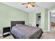 Bedroom showing a comfortable bed with a gray headboard, soft green walls and a peek into the closet at 1715 Larabie Ct, Brandon, FL 33511