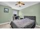 Comfortable bedroom featuring a large bed, modern ceiling fan and dedicated desk workspace at 1715 Larabie Ct, Brandon, FL 33511