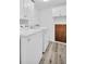 Bright laundry room featuring a washer, dryer, upper cabinets, and wood-look flooring at 1715 Larabie Ct, Brandon, FL 33511