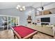 Spacious living room with a fireplace, pool table, and access to the backyard at 1715 Larabie Ct, Brandon, FL 33511