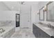 Spacious bathroom featuring double sinks, marble tile, and a glass shower enclosure at 18004 Clear Lake Dr, Lutz, FL 33548