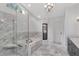 Elegant bathroom showcasing marble tile, a glass shower, tub, and dual vanity at 18004 Clear Lake Dr, Lutz, FL 33548
