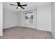 Bright bedroom features a ceiling fan, neutral carpet, and natural light from the window at 18004 Clear Lake Dr, Lutz, FL 33548