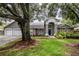 Inviting home with lush landscaping, mature shade tree, and a three-car garage at 18004 Clear Lake Dr, Lutz, FL 33548