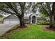 Charming home with a well-manicured lawn, lush landscaping, and mature trees providing shade and curb appeal at 18004 Clear Lake Dr, Lutz, FL 33548