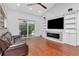 Bright living room with vaulted ceiling, fireplace, large tv, and hardwood flooring, perfect for entertaining guests at 18004 Clear Lake Dr, Lutz, FL 33548