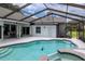 Inviting in-ground pool with screened enclosure and spa, perfect for outdoor relaxation and entertainment at 18004 Clear Lake Dr, Lutz, FL 33548