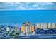 Aerial view showing the complex, ocean, parking and surrounding buildings with a picturesque sky at 18610 Gulf Blvd # 607, Indian Shores, FL 33785