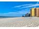 Beautiful beach view with white sand and clear blue skies near colorful beachfront condos at 18610 Gulf Blvd # 607, Indian Shores, FL 33785