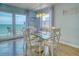 Well-lit dining area featuring a glass table, chairs, and access to the balcony at 18610 Gulf Blvd # 607, Indian Shores, FL 33785