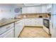 Charming kitchen with granite countertops, tile backsplash, and white cabinetry at 18610 Gulf Blvd # 607, Indian Shores, FL 33785