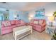 Living room with coral sofas and coastal decor, with a view looking to the balcony and the beach at 18610 Gulf Blvd # 607, Indian Shores, FL 33785