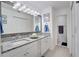 Bathroom with double granite vanity, decorative lighting, and entry to the water closet at 1933 Whitney Way, Clearwater, FL 33760
