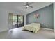Bright bedroom with light, wood-look flooring and a balcony overlooking trees at 1933 Whitney Way, Clearwater, FL 33760