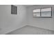 A clean bedroom featuring light gray flooring, neutral walls, and a sunlit window at 1933 Whitney Way, Clearwater, FL 33760