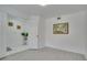 A minimalist bedroom featuring light gray flooring, and an open doorway leading to a tiled area at 1933 Whitney Way, Clearwater, FL 33760